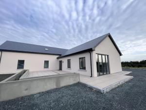a white house with a black roof at Modern Dunboyne Home in Dunboyne