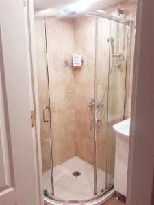 a shower with a glass door in a bathroom at Varna apartment in Varna City