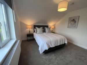 sypialnia z dużym łóżkiem z białą pościelą i poduszkami w obiekcie Modern Dunboyne Home w mieście Dunboyne