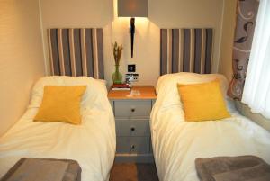 two beds sitting next to each other in a bedroom at Birch Tree Lodge 96 Main park in Jedburgh