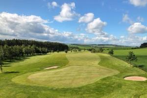 a view of a green golf course with trees at Birch Tree Lodge 96 Main park in Jedburgh