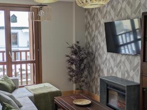 エスカリリャにあるLa Casa de la Montañaの暖炉とテレビのあるリビングルーム