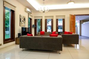 sala de estar con sofá y almohadas rojas en Kuah Town - Villa Indah, en Kuah