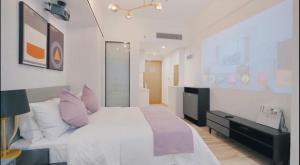 Una cama o camas en una habitación de Golden Central Hotel Serviced Residence-Xin Hao E Du金中环服务公寓新浩e都店