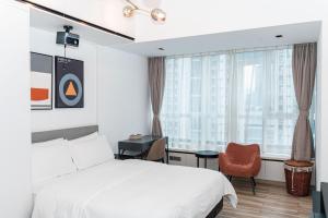 Una cama o camas en una habitación de Golden Central Hotel Serviced Residence-Xin Hao E Du金中环服务公寓新浩e都店