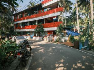 una motocicleta estacionada frente a un edificio en Abhi's cafe avaduthura kovalam, en Kovalam