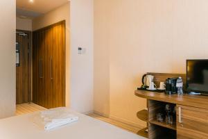 a hotel room with a bed and a tv and a door at Elements Kirov Hotel in Kirov