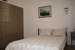 Selínia的住宿－Theatraki，卧室配有一张床,墙上挂着一幅画