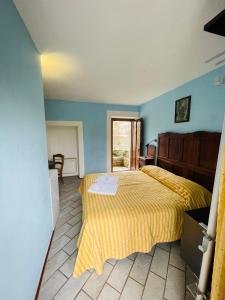 um quarto com uma cama amarela e uma janela em Agriturismo Gallo em Cortemilia