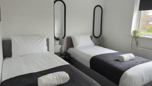 two beds sitting next to each other in a bedroom at Alexander Apartments Hebburn in Hebburn-on-Tyne
