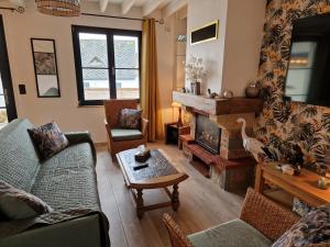 a living room with a couch and a fireplace at Maison cosy La Petite Cigogne en Baie de Somme in Boismont