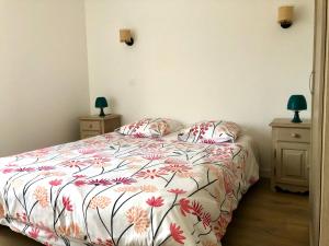 1 dormitorio con 1 cama con colcha de flores en La rocaille du château en Gréoux-les-Bains