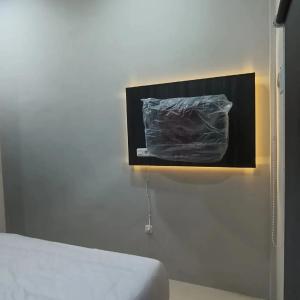 een kamer met een bed en een foto aan de muur bij Zio Zildan Homestay in Sibengkok
