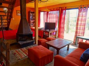 a living room with a fireplace and red furniture at Casa Amarilla con Jacuzzi in Punta Del Diablo