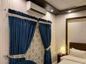 a bedroom with a bed and a blue curtain at Vactional Villa Dha Phase 6 Lahore ,Three Bed Room Full House in Lahore