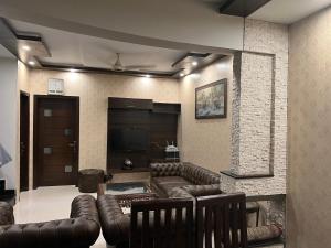 a living room with a leather couch and a television at Vactional Villa Dha Phase 6 Lahore ,Three Bed Room Full House in Lahore
