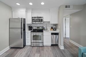 a kitchen with stainless steel appliances and white cabinets at Newly Renovated Condo with Private Balcony! in Panama City Beach