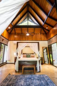 1 dormitorio con 1 cama en una habitación con techos de madera en Jade Nosara, en Nosara