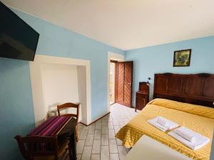 a bedroom with a bed and a table and a chair at Agriturismo Gallo in Cortemilia