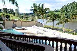 a balcony with a pool and a view of the water at Hotel Casa Branca in Monte Belo