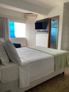 a bedroom with a large white bed and a television at Syros Hotel in Gama