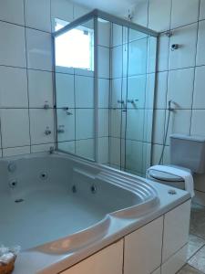 uma casa de banho branca com uma banheira e um WC em Syros Hotel em Gama