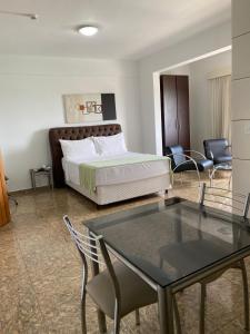 Syros Hotel في Gama: غرفة نوم بسرير وطاولة وكراسي