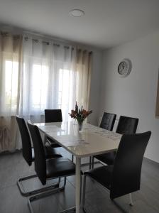 een eetkamer met een tafel en zwarte stoelen bij Zoran Vukusic Apartment in Kostrena