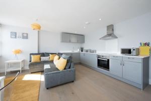 a living room with a couch and a kitchen at Beautiful, Spacious 1 bed flat in Brentwood