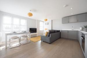 a kitchen and living room with a table and a couch at Beautiful, Spacious 1 bed flat in Brentwood