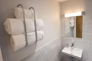 a bathroom with a stack of towels and a sink at Beautiful, Spacious 1 bed flat in Brentwood