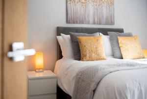 a bed with pillows and a lamp on a table at Beautiful, Spacious 1 bed flat in Brentwood