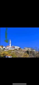 - une vue sur une ville avec un phare sur une colline dans l'établissement Bilocale Mirella, à Carro