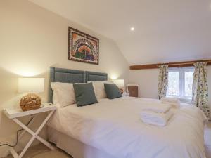 a bedroom with a large white bed and a table at Waldegrave Barn in Hartest