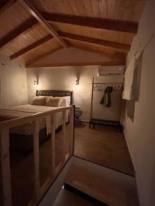 een slaapkamer met een bed in een kamer met houten plafonds bij Statha’s Home in Gythio