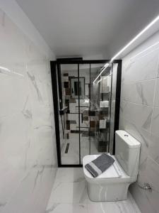 een witte badkamer met een toilet en een spiegel bij Statha’s Home in Gythio