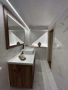 een badkamer met een wastafel en een spiegel bij Statha’s Home in Gythio