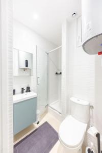 La salle de bains blanche est pourvue d'une douche et de toilettes. dans l'établissement Le Cocon Parisien - 3 min métro, à Vincennes