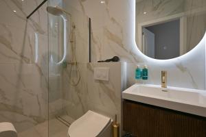 a bathroom with a shower and a toilet and a sink at Novallure Downtown - Short Stay Apartments in The Hague