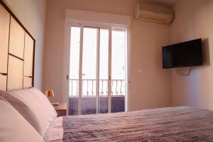 - une chambre avec un lit, une télévision et une fenêtre dans l'établissement BUNGALOW PUERTO SANTA POLA PISCINA CLIMATIZADA, à Santa Pola
