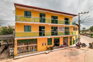 a yellow building on the side of a street at POUSADA DA ILHA in Una