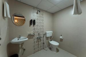 a bathroom with a toilet and a sink at Sai Bliss International, Bangalore in Bangalore