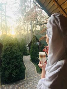 a woman holding a cup of coffee looking out a window at Фортеця in Kyiv