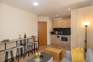 a living room and kitchen with a couch and a table at Grand Central , 2 double bedroom apartment with free parking , Birmingham in Birmingham