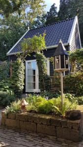 una pequeña casa con una casa de aves en un jardín en Tiny House Tholen, en Tholen
