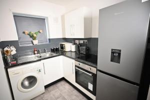 una piccola cucina con lavandino e lavastoviglie di Bubble Rooms a Manchester