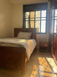 una camera con un letto e due finestre di Beautiful Cozy Mansion a Kampala