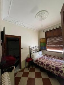 1 dormitorio con 1 cama y suelo a cuadros en Hôtel Restaurant Ali, en Midelt