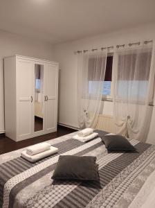 - une chambre avec 2 lits avec des oreillers et un miroir dans l'établissement Zoran Vukusic Apartment, à Kostrena