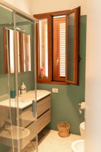 ein Bad mit einem Waschbecken und einem Spiegel in der Unterkunft Villa Julia, magia del sud in Sampieri